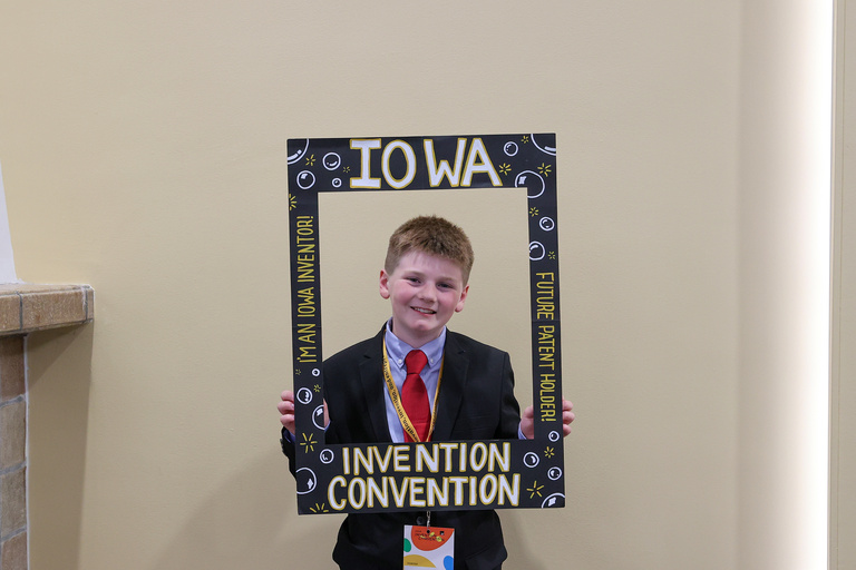 Student inventor taking picture at photo booth