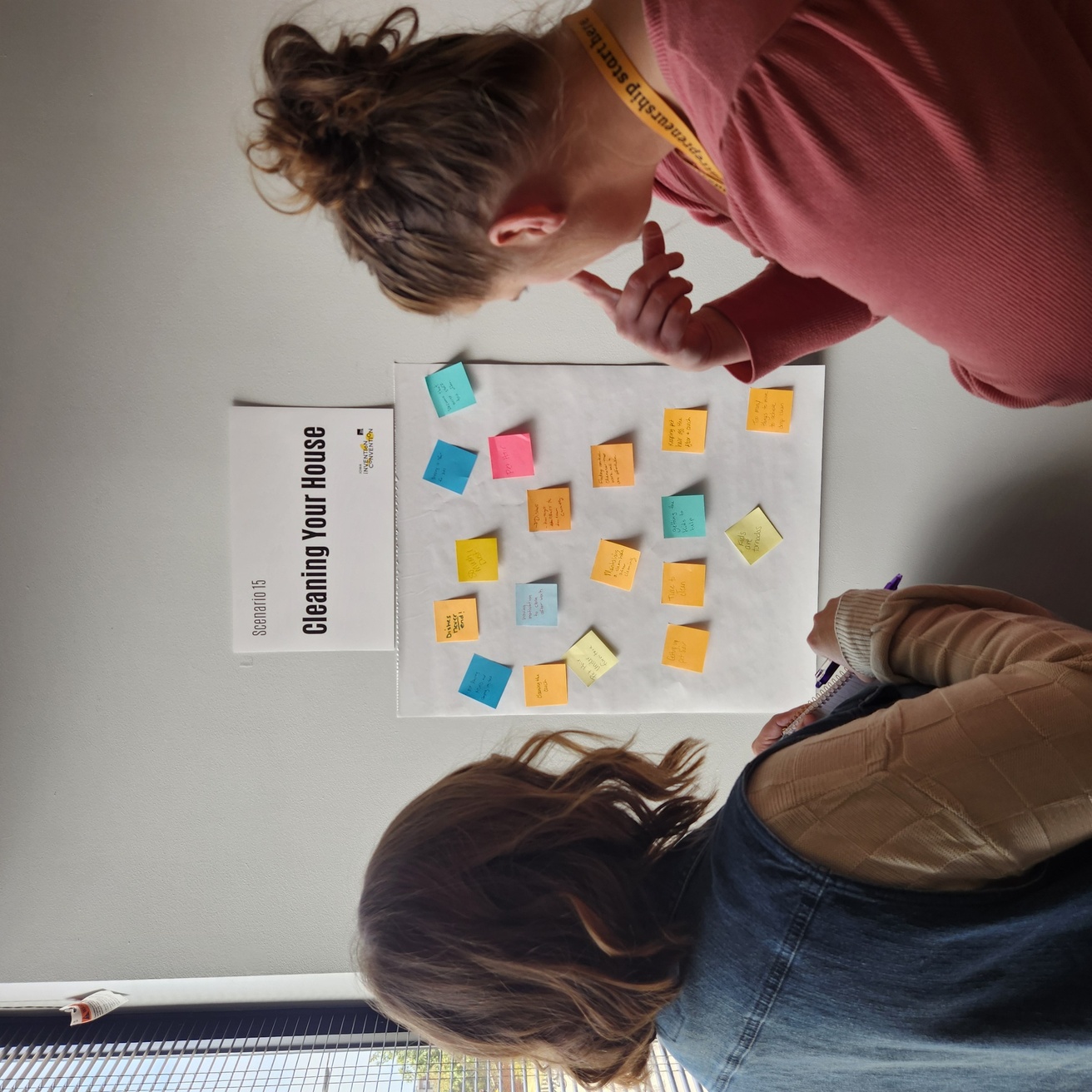 Teachers brainstorming new ideas with post-it notes to put on the board in front of them.
