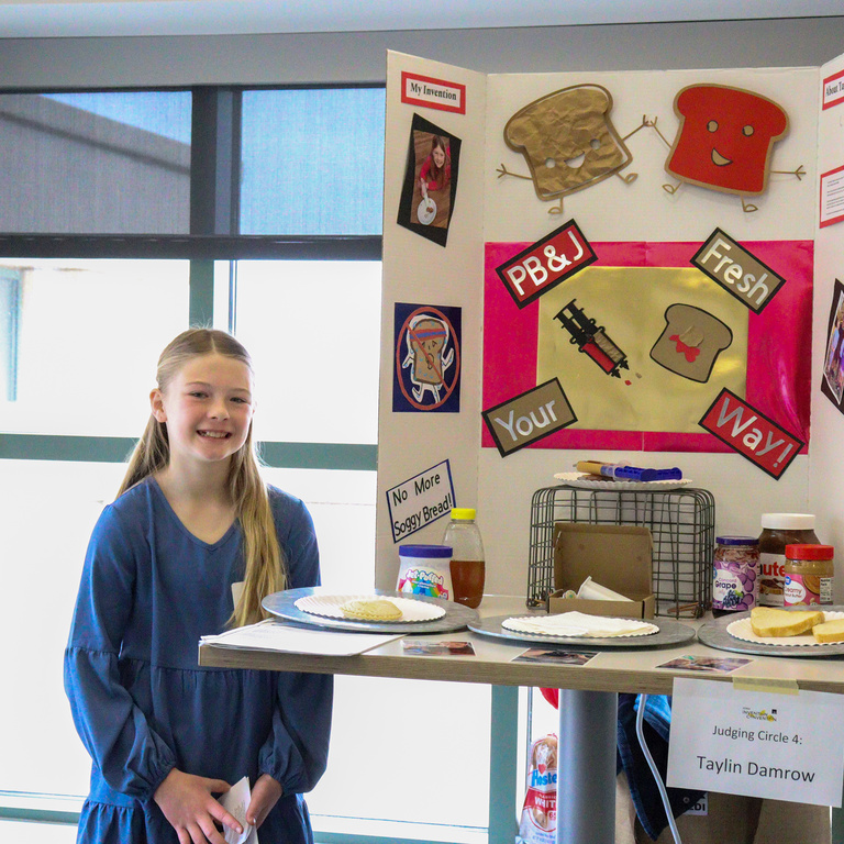 Inventor standing next to her "Sandwich Filler" project at the Iowa Invention Convention