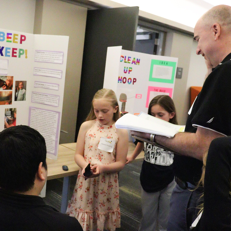 Two girl inventors presenting at the 2025 Iowa Invention Convention